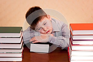 Tired kid with stack of books