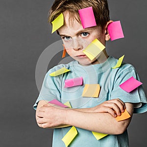Tired kid sulking with crossed arms with notes on face