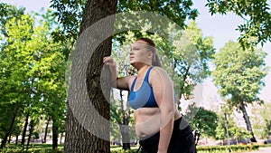 Tired lady hardly breathing after jogging, cardio training system, overweight photo