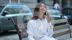 Tired lady sitting on bench, suffering from head ache, meteorological dependence