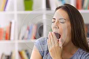 Tired lady yawning at home