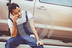 Tired and lazy mechanic repairing customer cars.