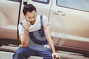 Tired and lazy mechanic repairing customer cars.