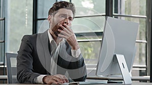 Tired lazy napping yawn adult bearded man male manager worker bored at work project online in computer in office