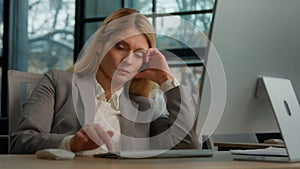 Tired lazy sad adult middle-aged woman female manager employee worker bored at work project online in computer in office