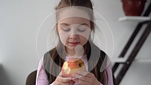 Tired of lessons, pupil eats a large juicy fresh apple for lunch. A useful fruit for the health of schoolchildren. Snack