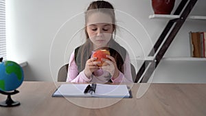 Tired of lessons, pupil eats a large juicy fresh apple for lunch. A useful fruit for the health of schoolchildren. Snack