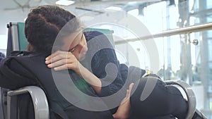 Tired lifestyle girl teen traveler sleeping on the airport waiting for the plane departure gates bench with all her