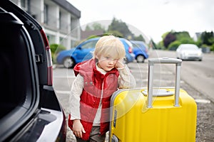 Tired little boy ready for going to road trip with his parents