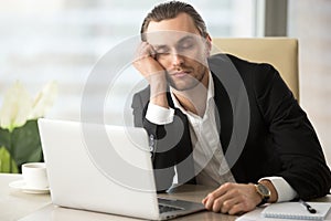 Tired male entrepreneur slumbers at work photo