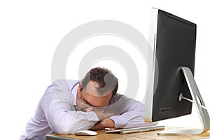 Tired man asleep at desk with computer working photo
