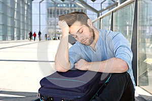 Tired man with bag sleeping at airport