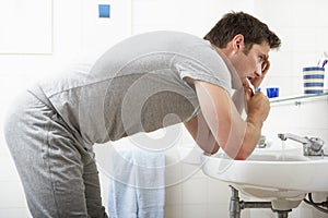 Tired Man In Bathroom Brushing Teeth