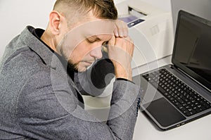 Tired man with closed eyes and head leaning against hands