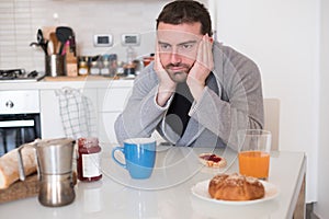 Tired man feeling bad during the early morning breakfast