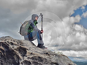 Tired man hiker enjoy the view at mountain peak cliff