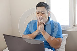 Tired Man Looking at Laptop