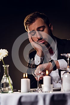 tired man looking at watch while waiting for romantic date