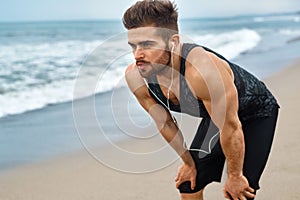 Tired Man Resting After Running On Beach. Sports Workout Outdoor