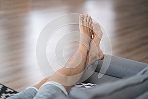 Tired man resting after work at home, male feet, body care concept