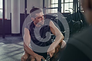 Tired man sitting after battle rope exercise