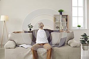 Tired man sleep on sofa distracted from computer work