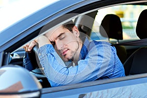 Tired man sleeps in car