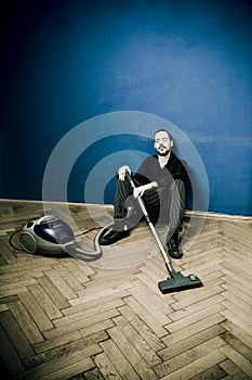 Tired man with vacuum, resting