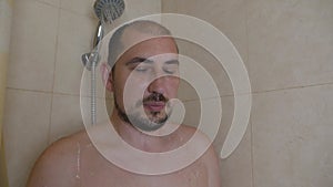 Tired man washes in the shower.Man relaxing in the shower