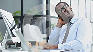 tired man works at a computer on background office. concept of trouble at work