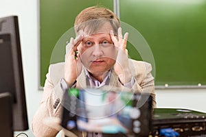 A tired math teacher clutched his head during