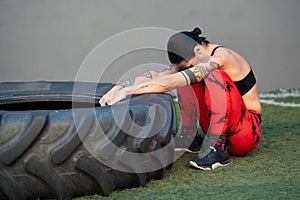 Tired mature sportive woman training with wheel in a gym