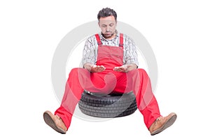 Tired mechanic looking at his dirty hands