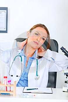 Tired medical doctor woman massaging her neck