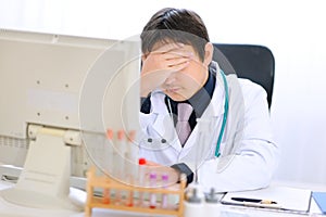 Tired medical doctor working on computer at office