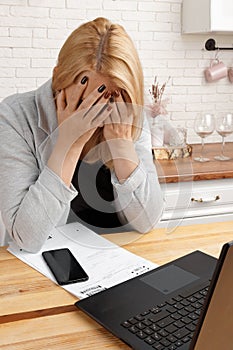 tired middle-aged business woman working in a home office, sitting at a desk with documents