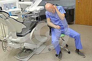 Tired, middle aged dentist - Neck pain in the dental practice