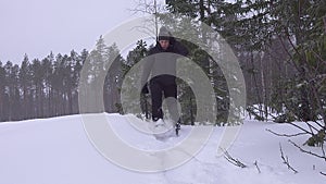 Tired middle aged man walks in snow shoes in forest covered in freshly fallen snow. Snow shoes makes the walk much easier. Sweden