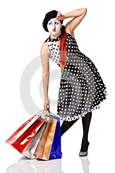 Tired mime in spotty dress holding shopping bags