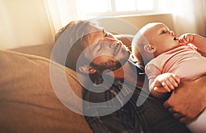 Tired, morning and father with baby on sofa for bonding, care and relax for parenting. Family, home and dad with newborn