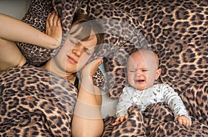 Tired mother can`t to sleep because her baby is crying