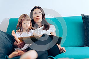 Tired Mother Reading to Her Daughter a Story at Home