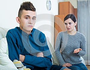 Tired mother rebuking teenage son at home