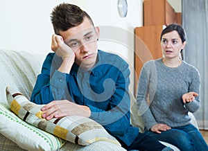 Tired mother rebuking teenage son at home