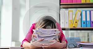 Tired office worker is overloaded with paperwork in office