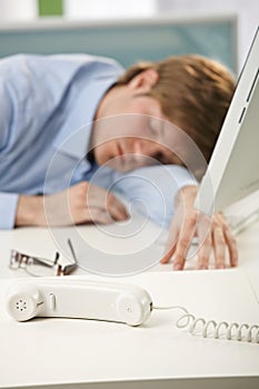 Tired office worker sleeping at desk