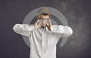 Tired office worker suffers from severe headaches caused by stress and emotional burnout.