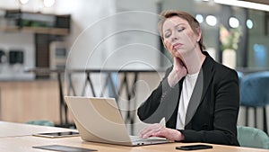 Tired Old Businesswoman having Neck Pain in Office