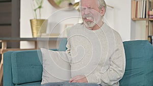 Tired Old Man having Back Pain on Sofa