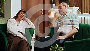 Tired old people falling asleep on sofa